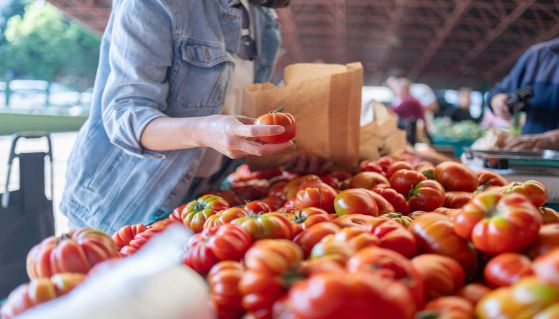 Persona compra pomodori al mercato 