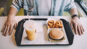 Uomo al fast food che mangia un menu classico