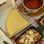Persona prepara le lasagne di pane carasau