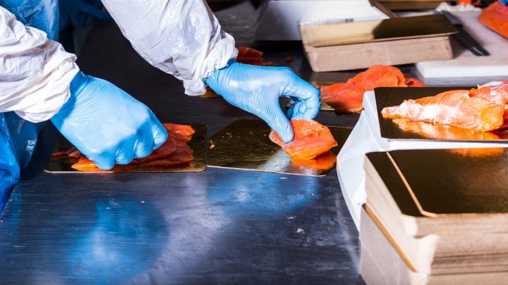Operaio si occupa della produzione di salmone affumicato