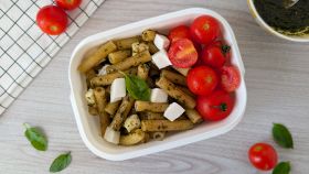 Tavola con schiscetta con pasta al pesto e mozzarella