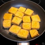 Padella con cubetti di tofu in cottura