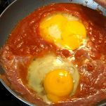 Uova cuociono in padella con il pomodoro