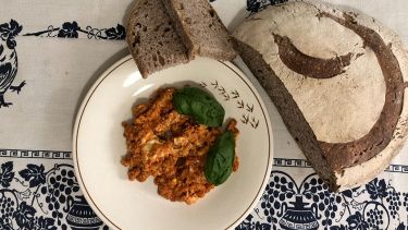 Uova strapazzate al pomodoro sul tavolo apparecchiato