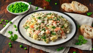 Russian traditional salad Olivier with vegetables and meat.