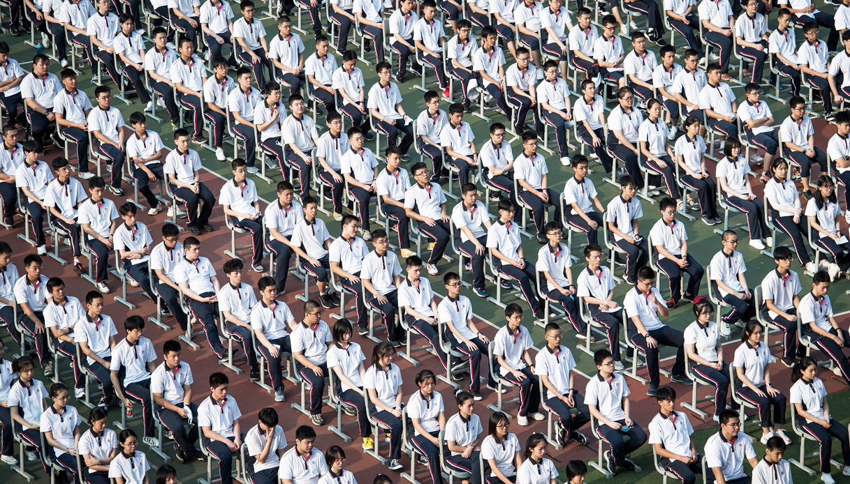 Riaprono le scuole a Wuhan. Studenti assistono all'alzabandiera