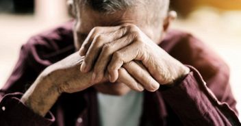 senior man covering his face with his hands.vintage tone