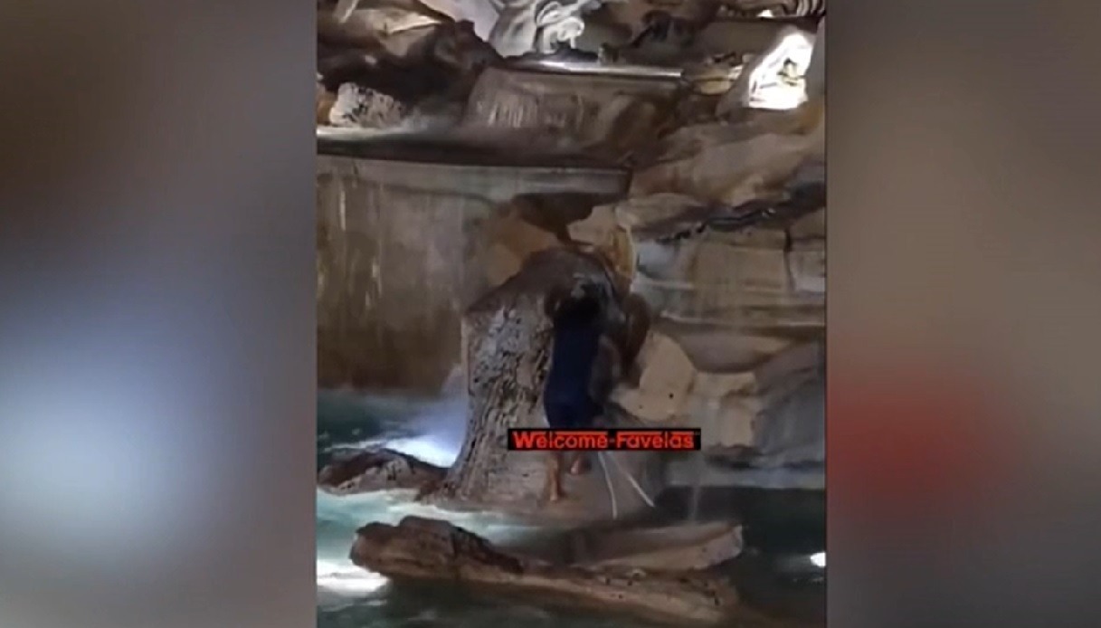 Uomo entra nella fontana di Trevi e si tuffa.