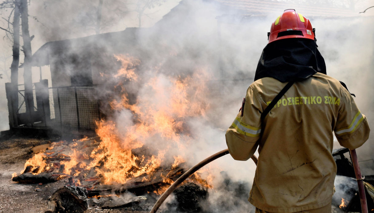 Un pompiere greco spegne un incendio