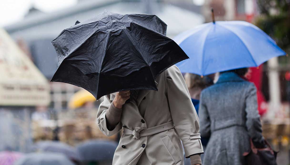 Un uomo con l'ombrello sotto la pioggia