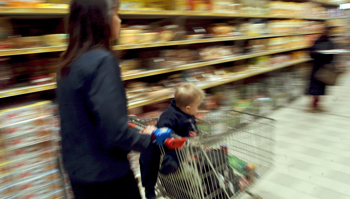 Donna con bambino al supermercato