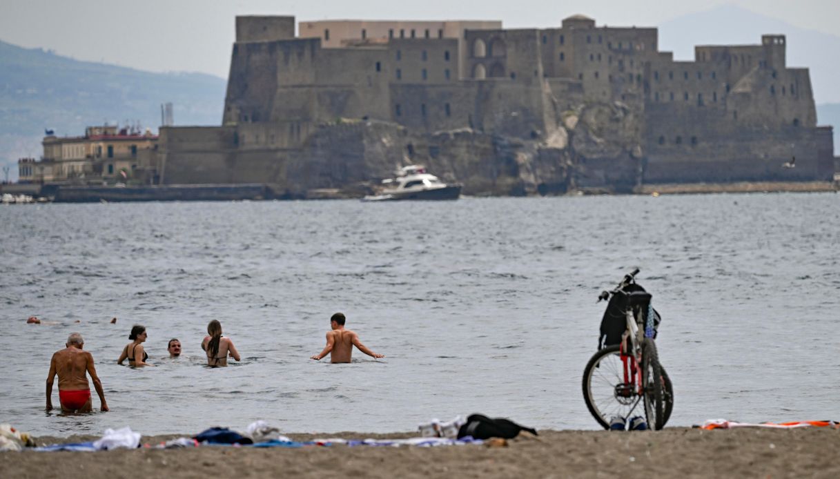 Inondazione a Milano e caldo estivo a Napoli, le immagini della gente in costume da bagno sul lungomare