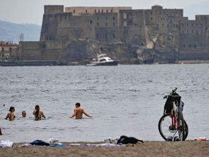 Inondazione a Milano e caldo estivo a Napoli, le immagini della gente in costume da bagno sul lungomare
