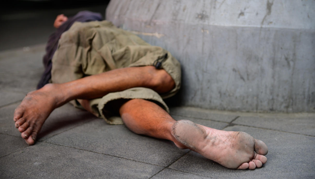 Un senzatetto dorme per strada