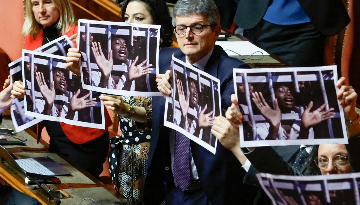 Deputati con foto delle vittime di Almasri