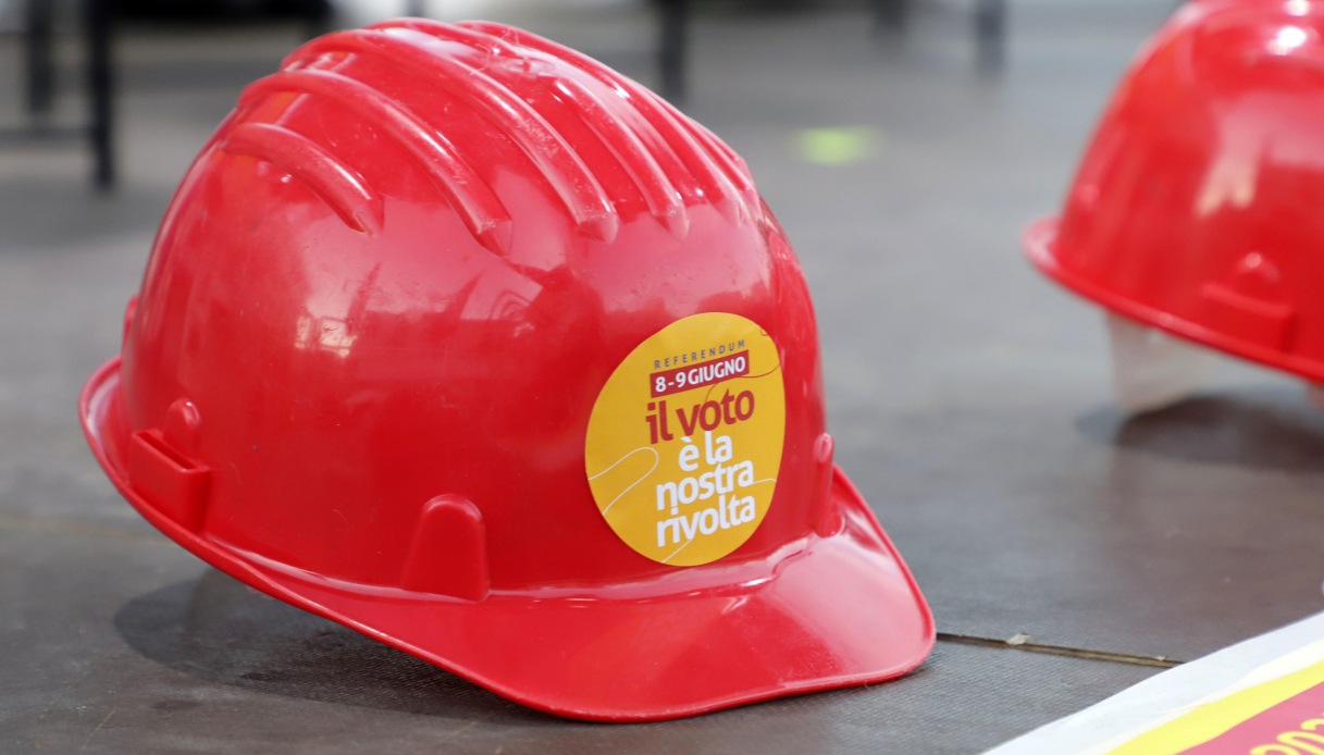 Un cappello protettivo da lavoro con l'adesivo per invitare a partecipare al referendum