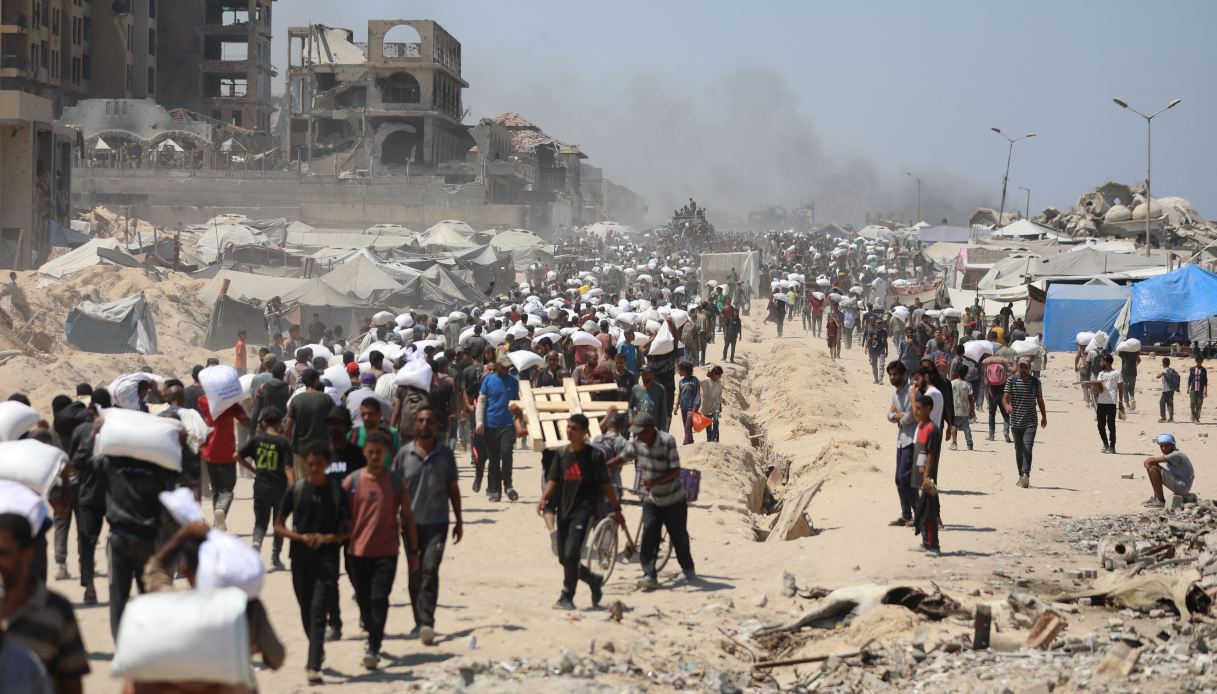 Palestinesi in coda per ricevere aiuti umanitari nella striscia di Gaza