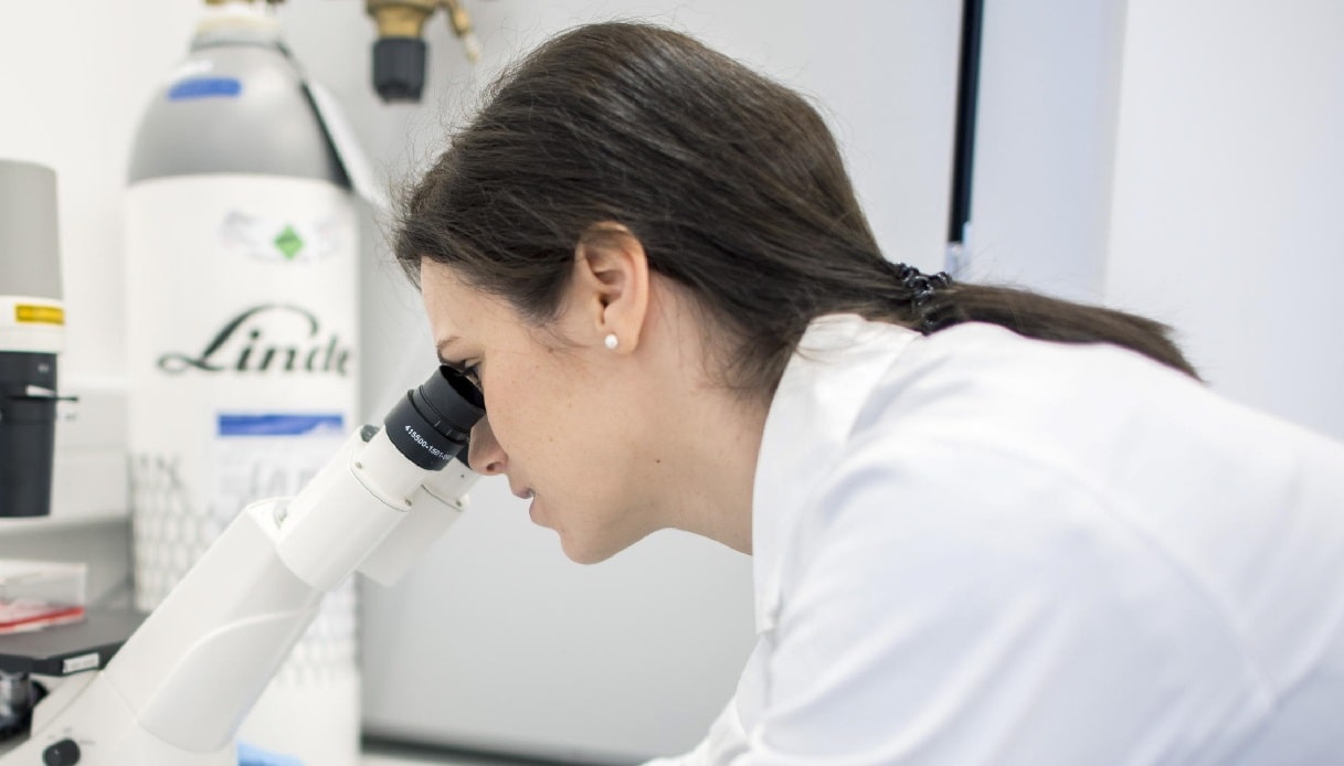 Dottoressa guarda il microscopio