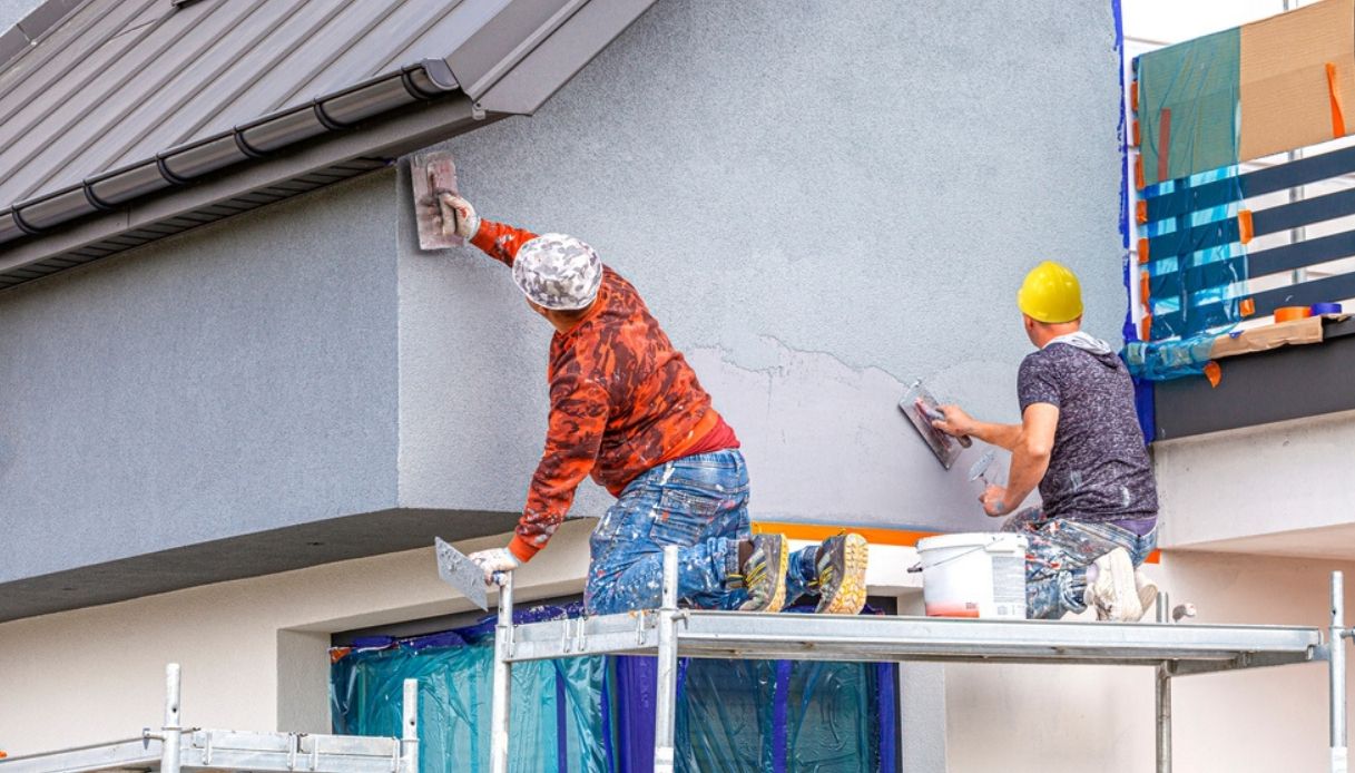 Operai lavorano sulla facciata di una casa