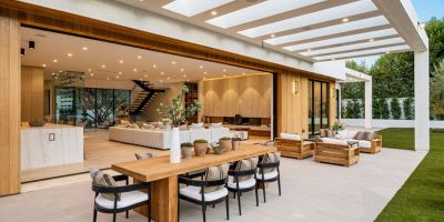 Dal Salone del Mobile 2025 le tendenze e le migliori idee per arredare una terrazza, un giardino o altro spazio outdoor come quello in foto, un grazioso giardino con area pranzo, pergolato e un prato verde tutto intorno