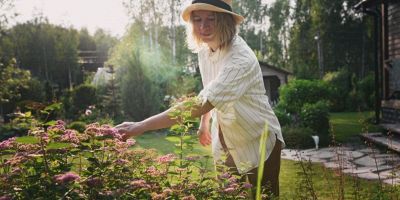 una donna si prende cura del giardino in primavera sapendo quali fiori e piante piantare