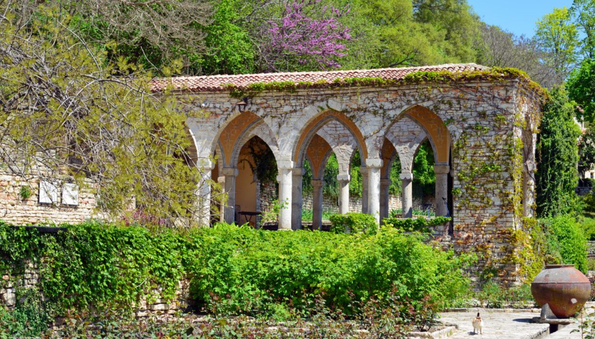 Gazebo in pietra in giardino con piante rampicanti