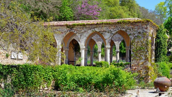 Gazebo in pietra in giardino con piante rampicanti