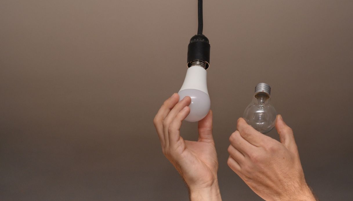 una persona sostituisce la vecchia lampada alogena con una a led