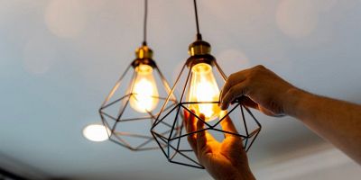 una persona sostituisce la lampada alogena con un nuovo modello di lampada LED