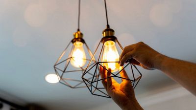 una persona sostituisce la lampada alogena con un nuovo modello di lampada LED