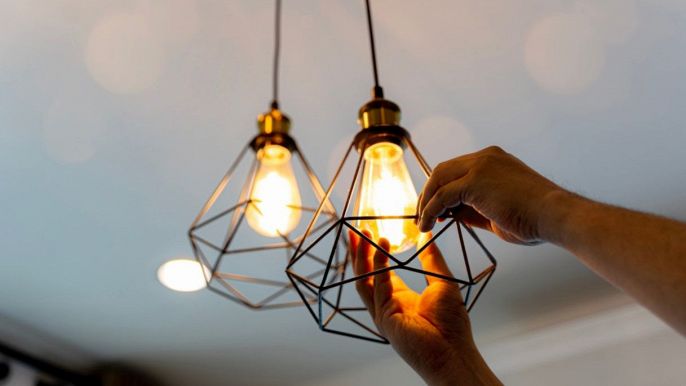 una persona sostituisce la lampada alogena con un nuovo modello di lampada LED