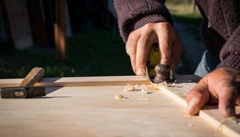 falegname che lavora al legno d'abete per creare mobile su misura