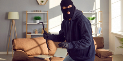 ladro con passamontagna che entra in casa