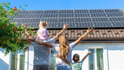 famiglia felice davanti a impianto fotovoltaico