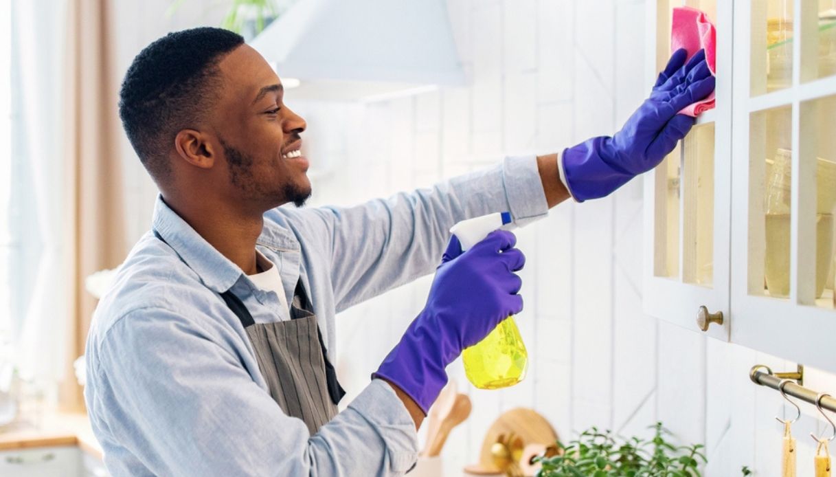 persona pulisce ante della cucina