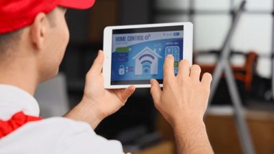 persona che installa un sistema di allarme in un piccolo appartamento