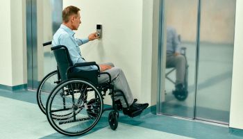 persona in sedia a rotelle che prenota l'ascensore