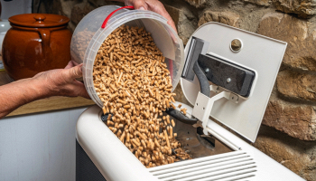 uomo inserisce pellet nella stufa
