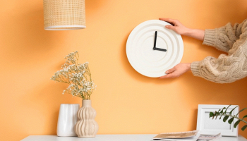 ragazza appende un orologio alla parete