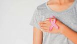 womaen hand holding pink ribbon breast cancer awareness. concept