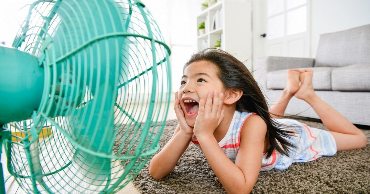 La bambina con movimento nel vento ha i capelli bianchi che tengono il  ventilatore e urlano bambino e ventilatore su sfondo giallo