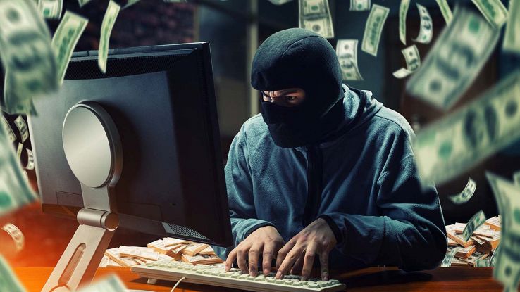 Hacker al lavoro circondato da soldi
