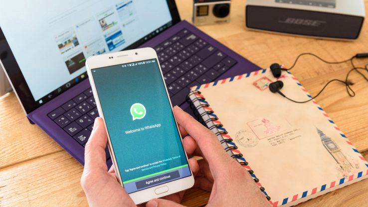 Un utente tiene in mano uno smartphone mentre lancia l'app di WhatsApp