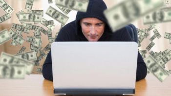 Hacker circondato da denaro