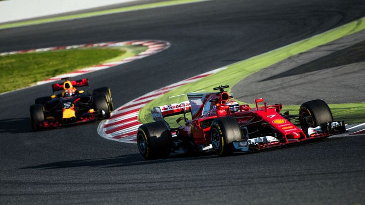 Una Ferrari precede una Red Bull in una curva a esse