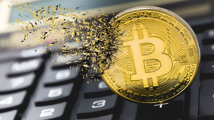 Lo stemma del Bitcoin va smaterializzandosi su una tastiera da PC