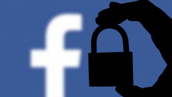 Il logo di Facebook e l'ombra di un lucchetto