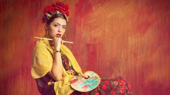 Una donna vestita da pittrice impersonifica l'artista Frida Khalo
