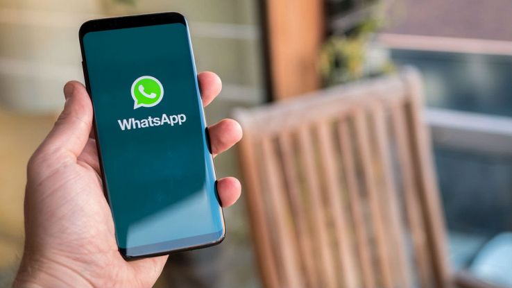Un utente tiene in mano il proprio smartphone con l'immagine di WhatsApp sullo schermo