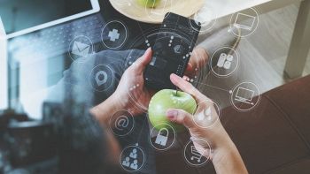 Un utente tiene in mano un iPhone e una mela